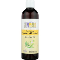 A bottle of Aura Cacia Sweet Almond Skin Care Oil next to a bowl of almonds.